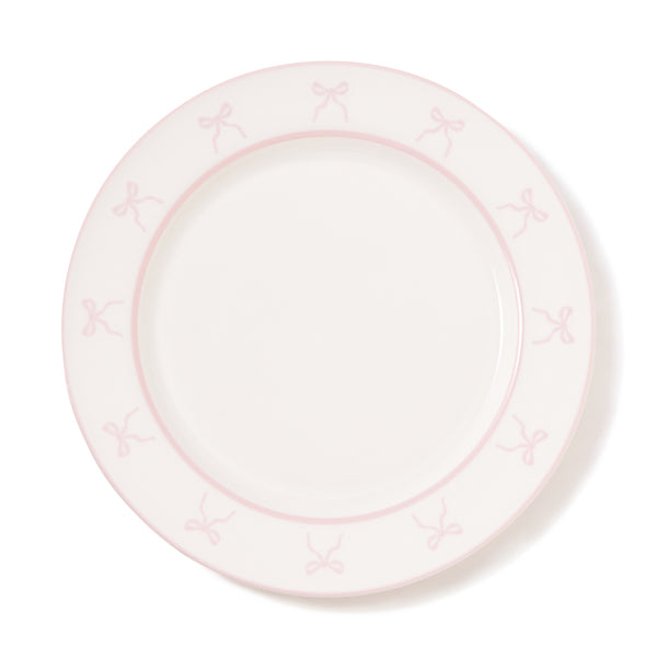 Round porcelain plate with a pink ribbon border pattern on a white background.