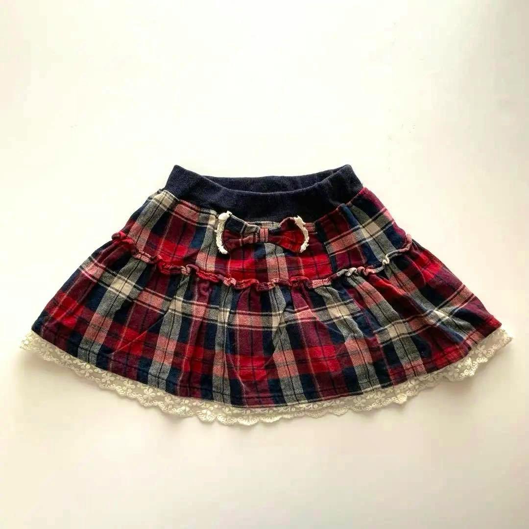 A check-pattern skirt (110cm) with a bow at the waist and lace trim, laid flat on a white background.