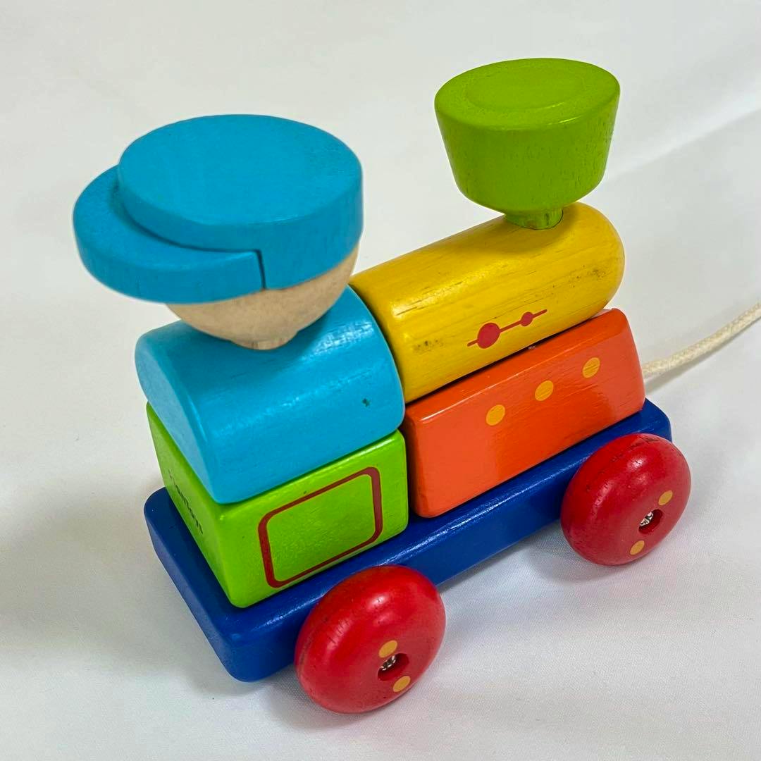 Colorful wooden pull-along sorting train made of stacked blocks on a blue wheeled base.