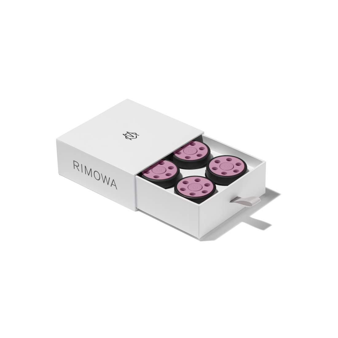 A white drawer-style box holding four pink suitcase wheels displayed on a black background.