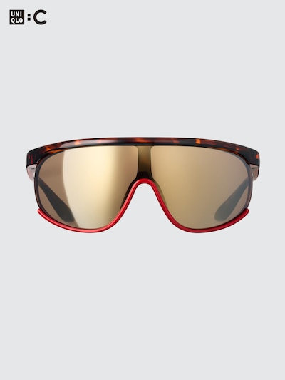 Front view of the plastic sunglasses showing tortoiseshell frame, gold mirrored lenses, and red trim on a light gray background.