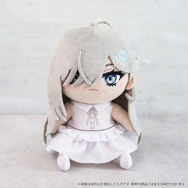 Front view of the plush toy showing gray hair, embroidered facial features, and a pale dress against a neutral background.