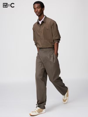 Male model wearing the tuck wide tapered pants shown full-length.