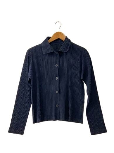 Front view of a dark pleated men's cotton shirt (PLEATS PLEASE ISSEY MIYAKE) hanging on a wooden hanger against a white background.