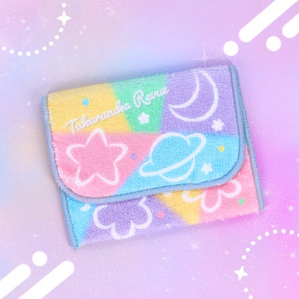 Folded polyester pocket towel with pastel color blocks and star, planet, moon, and flower motifs.