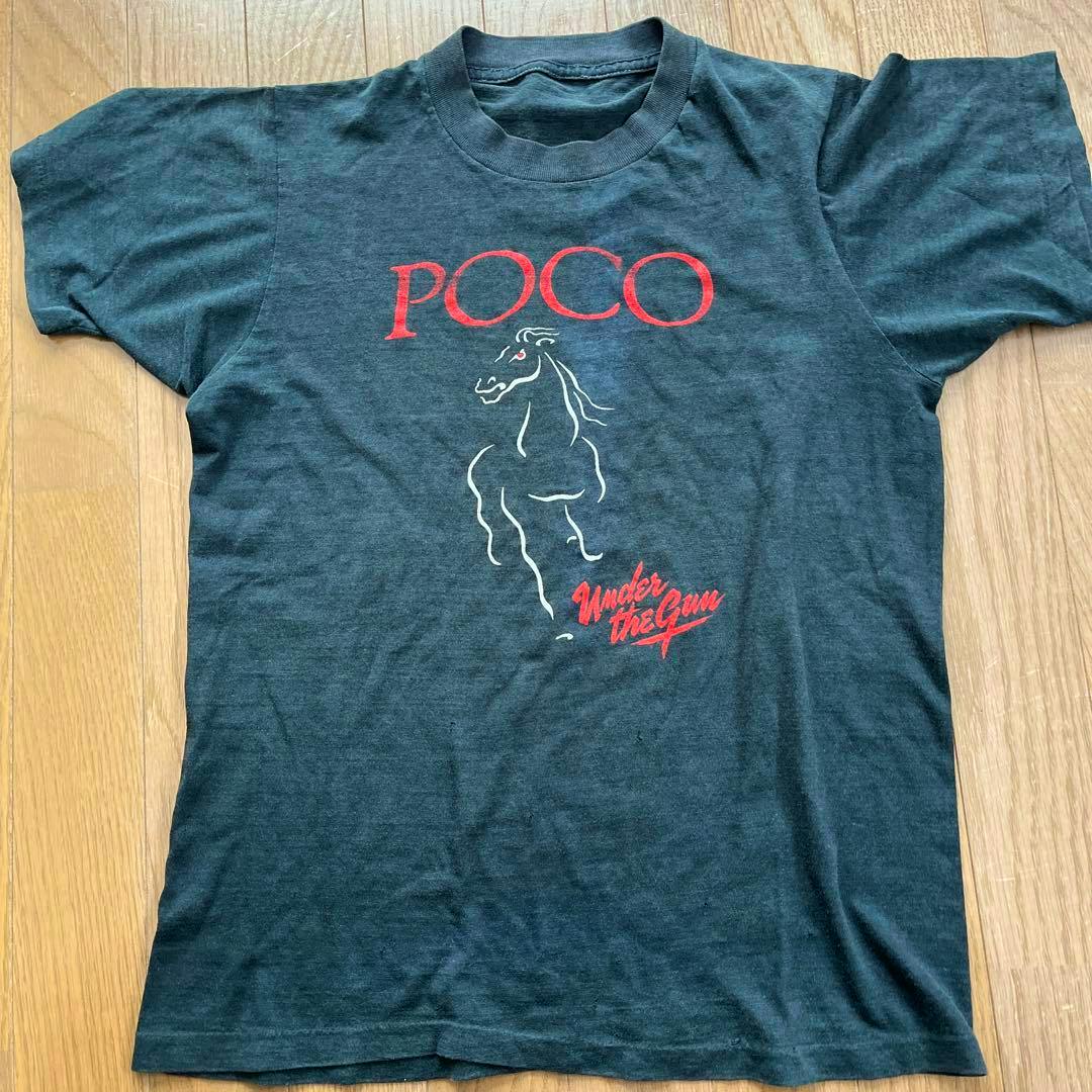 A dark gray men's cotton T-shirt laid flat showing the front print reading “POCO” with a horse graphic and “Under the Gun.”