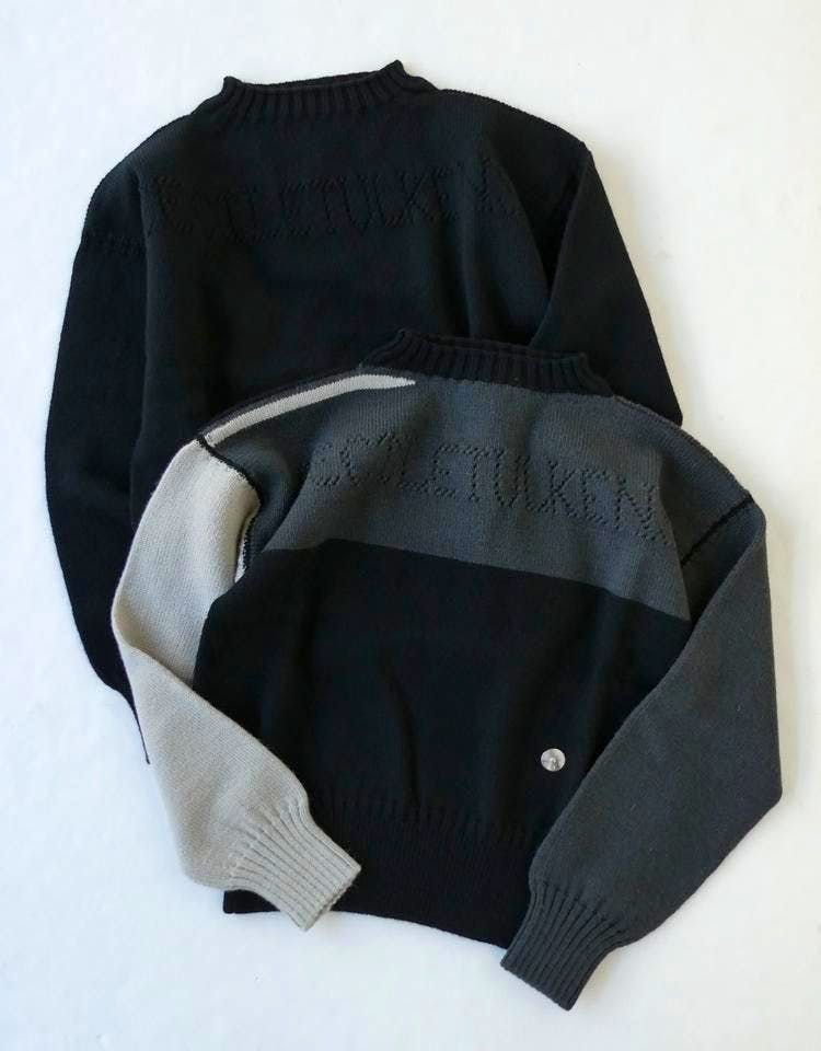 Two wool sweaters laid flat, one black and one gray-and-black colorblock, showing the back and sleeves.