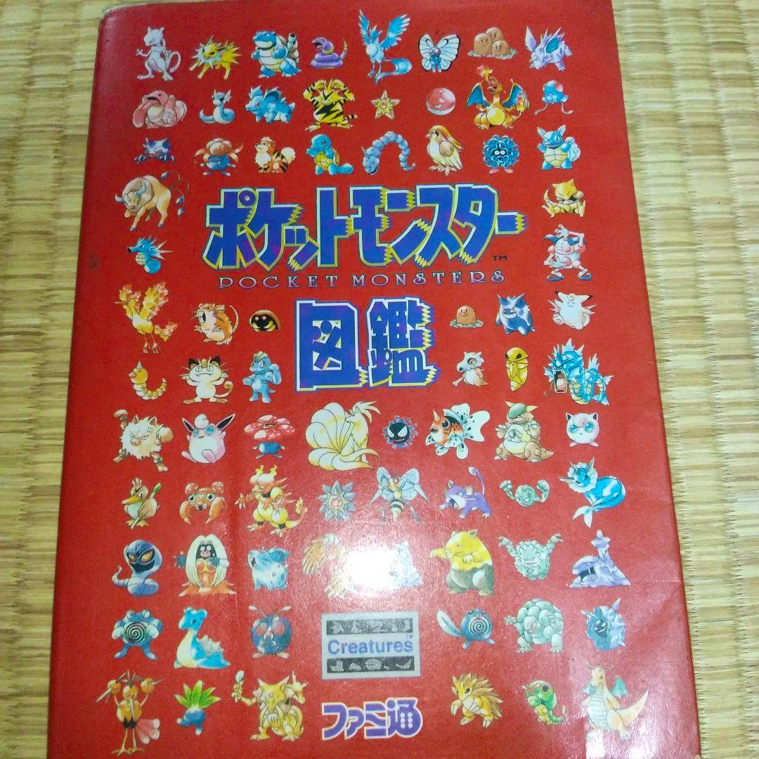 Front cover of the Japanese ポケットモンスター図鑑 book showing many Pokémon illustrations on a red background with the title.