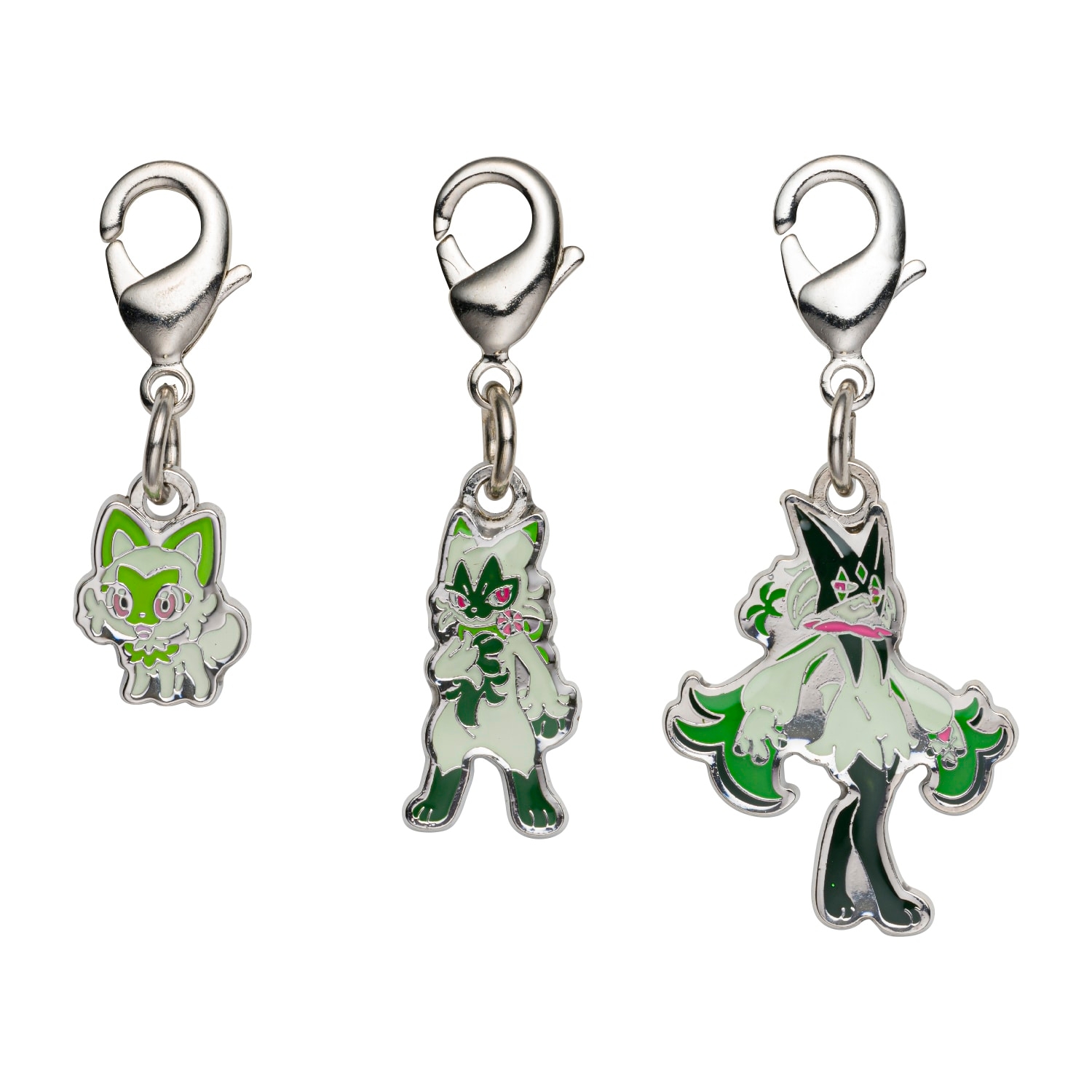 Three metal keychain charms with lobster-clasp attachments showing green-and-white character designs on a white background.