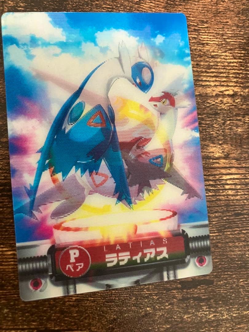 Photograph of a Pokémon trading card showing Latios and Latias artwork with Japanese card text.