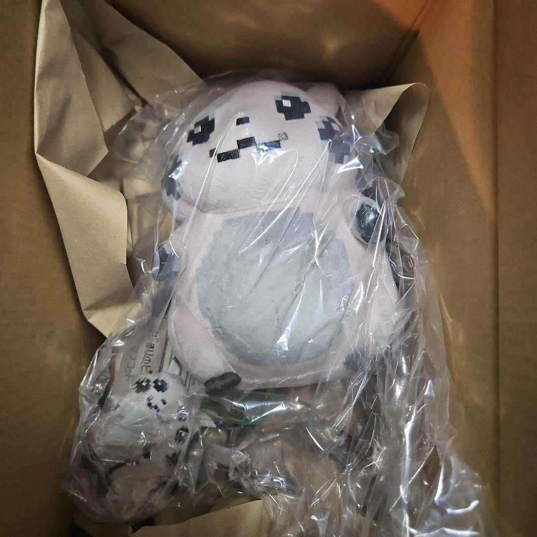 A Pikachu mascot plush wrapped in clear plastic inside a cardboard shipping box.