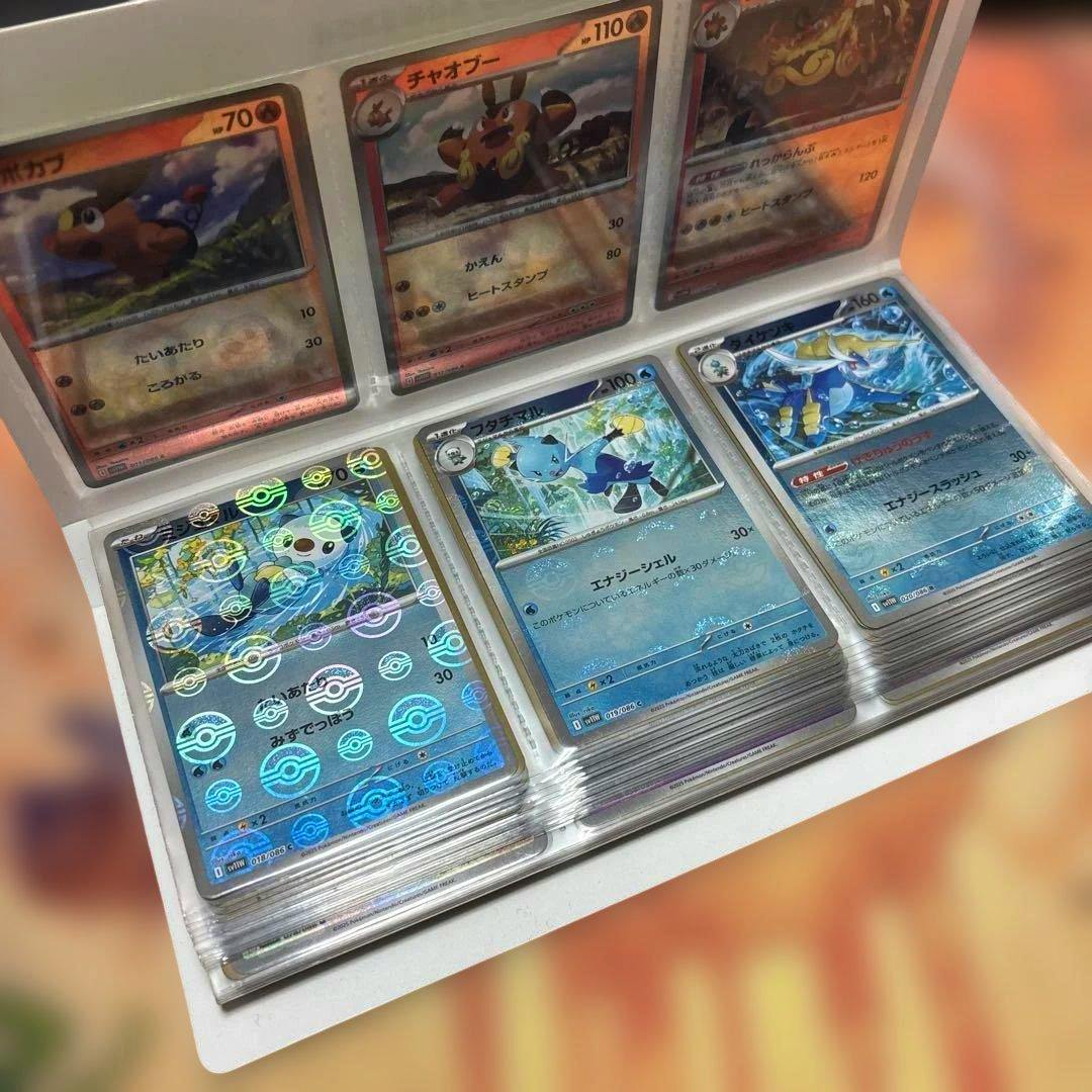 Multiple trading cards displayed in plastic binder sleeves, including holographic mirror-pattern cards.