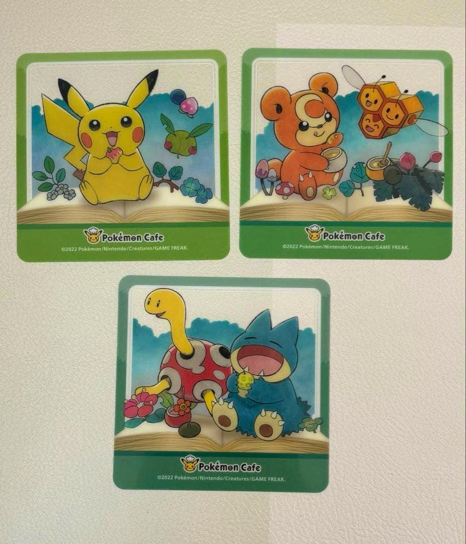 Three square Pokémon Cafe coasters arranged on a light background, featuring Pikachu, Teddiursa with Combee, and Shuckle with Munchlax.