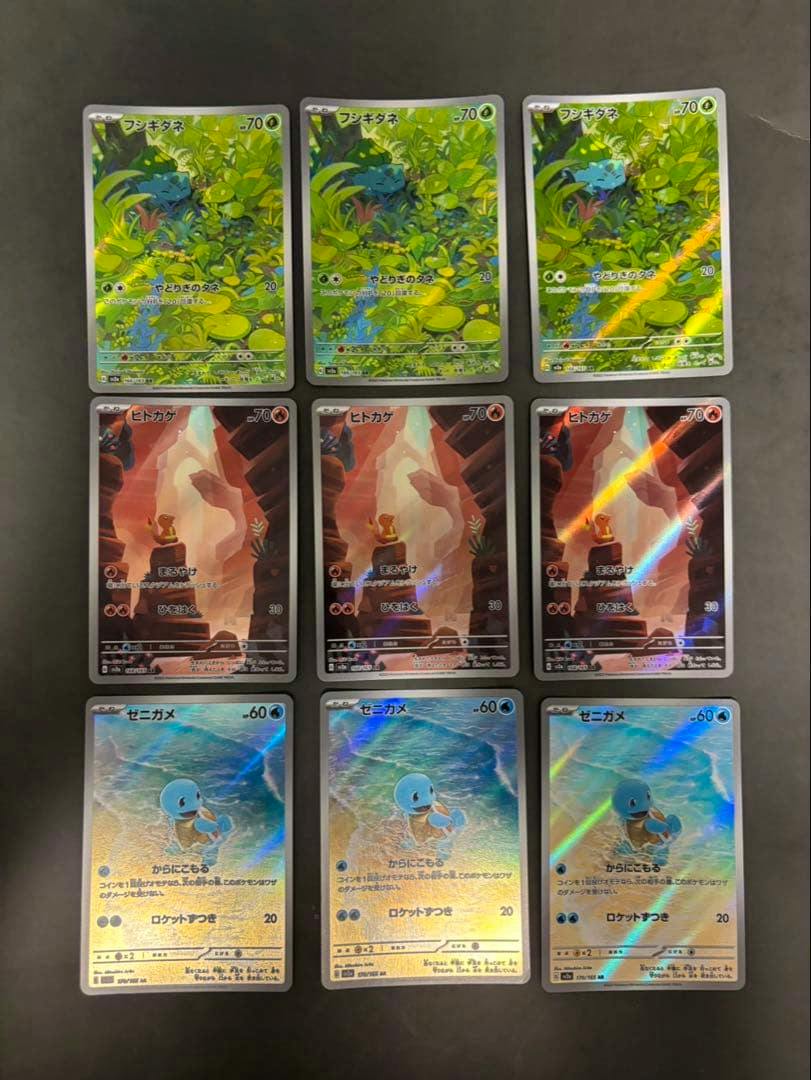 Front faces of nine Pokémon trading cards arranged in a 3x3 grid, featuring Bulbasaur (フシギダネ), Charmander (ヒトカゲ), and Squirtle (ゼニガメ) artwork.