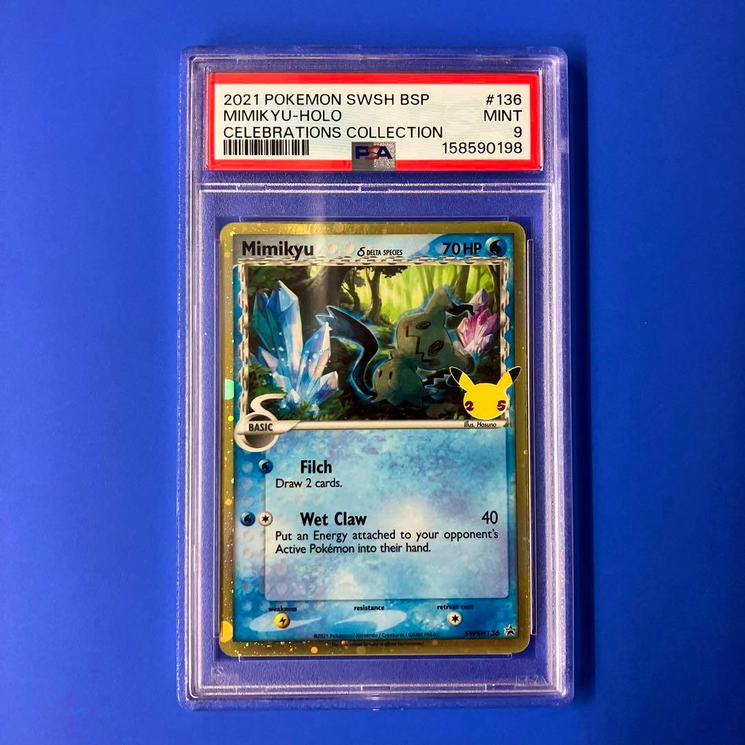 PSA-graded Mimikyu holographic Pokémon trading card in a clear slab with a PSA label showing a Mint 9 grade, photographed on a blue background.