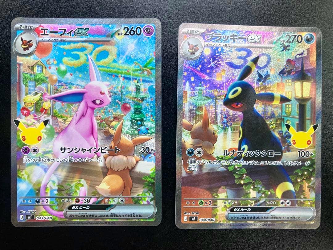 Front holographic faces of two Pokémon trading cards showing Espeon ex (left) and Umbreon ex (right) on a dark background.