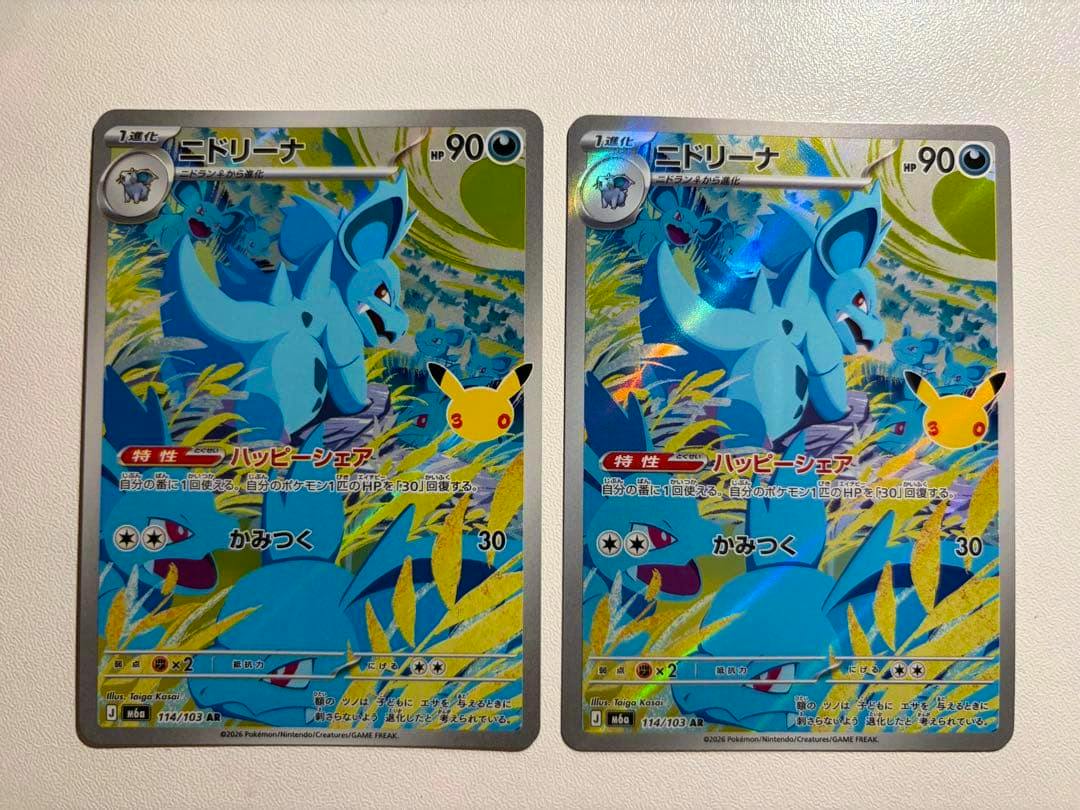 Fronts of two Pokémon trading cards showing the ニドリーナ (Nidorina) 30周年 AR artwork, cards 114/103, side-by-side on a white background.