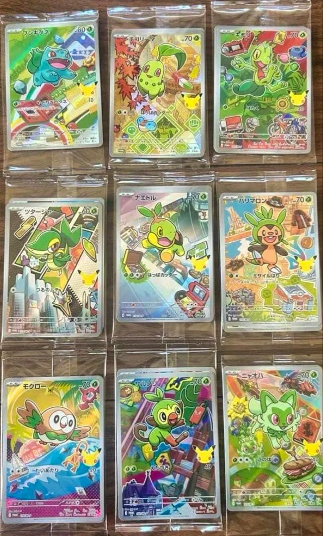 Nine Pokémon promo cards in protective sleeves arranged in a 3x3 grid on a wooden surface.