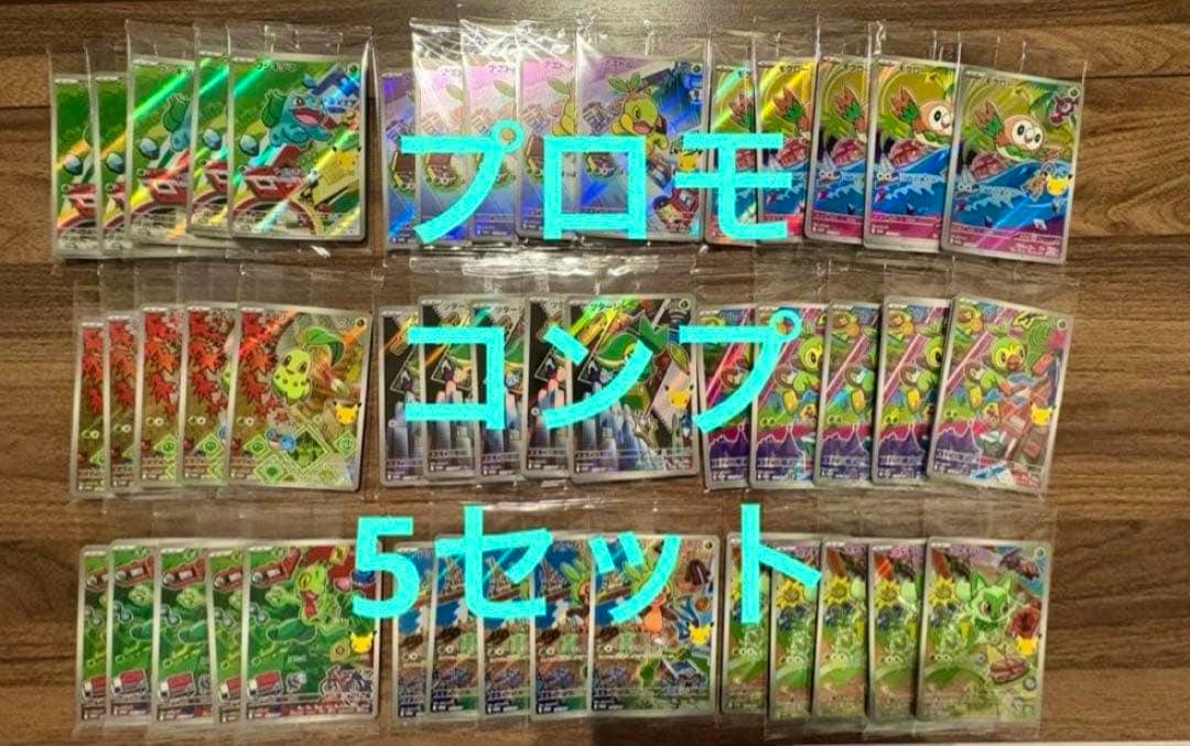 Photo of multiple Pokémon trading cards from the 30th anniversary starter promo sets arranged in rows on a wooden surface with blue Japanese overlay text.