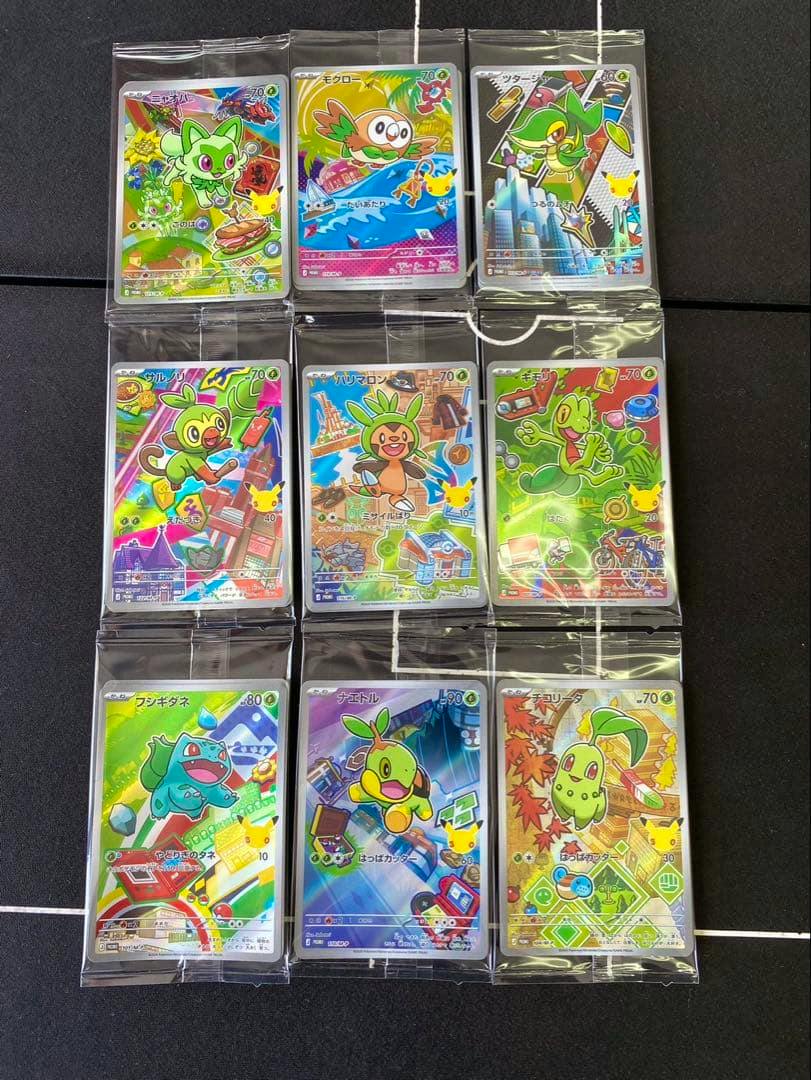 Nine sleeved Pokémon 30th anniversary starter promo trading cards arranged in a 3x3 grid on a black surface.