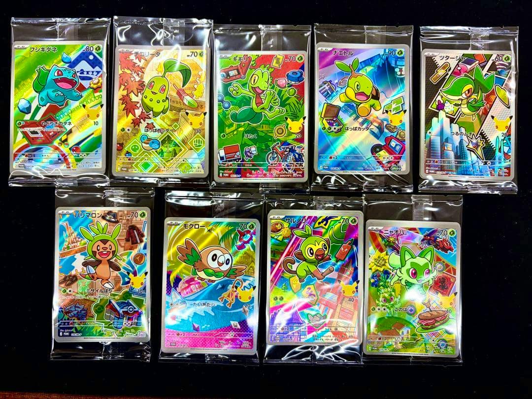 Several Pokémon 30th anniversary AR holographic trading cards in protective sleeves arranged on a dark background.