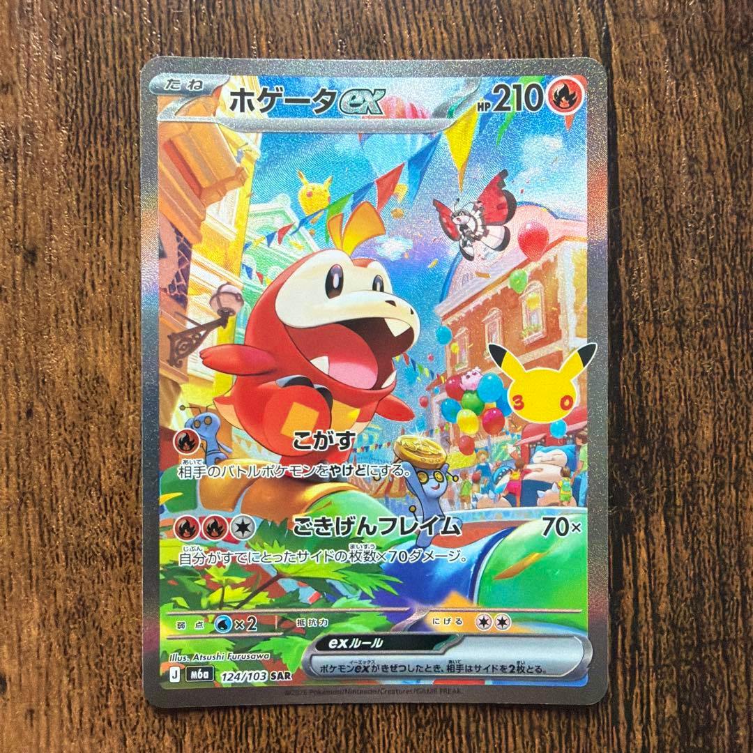 Front of the Pokémon trading card "ホゲータex" (124/103 SAR) photographed on a wooden surface.