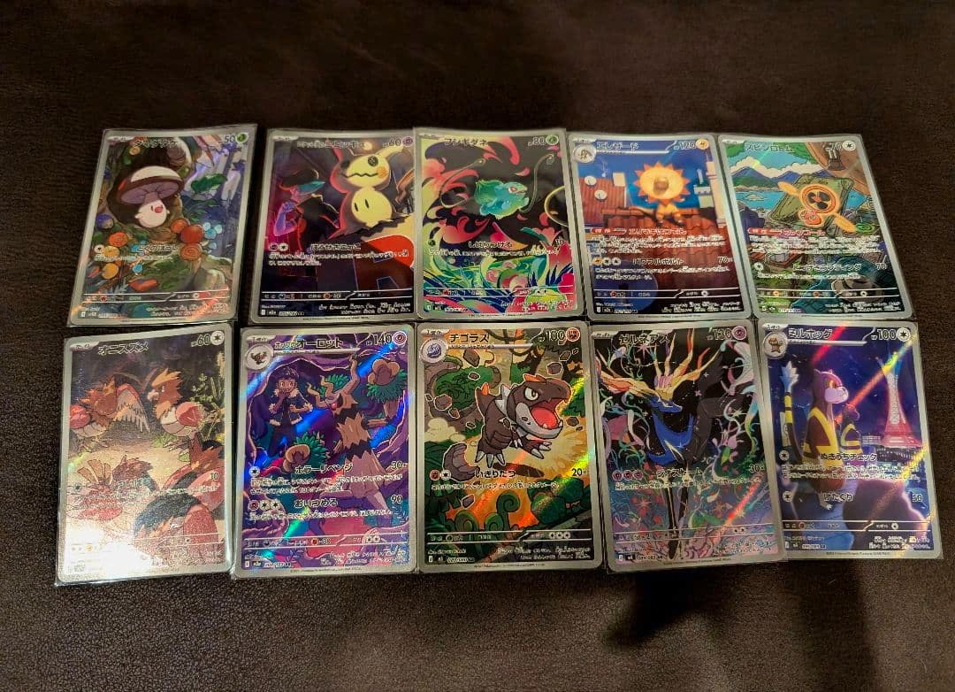 Ten Pokémon trading cards with holographic artwork shown face-up in two rows on a dark surface.