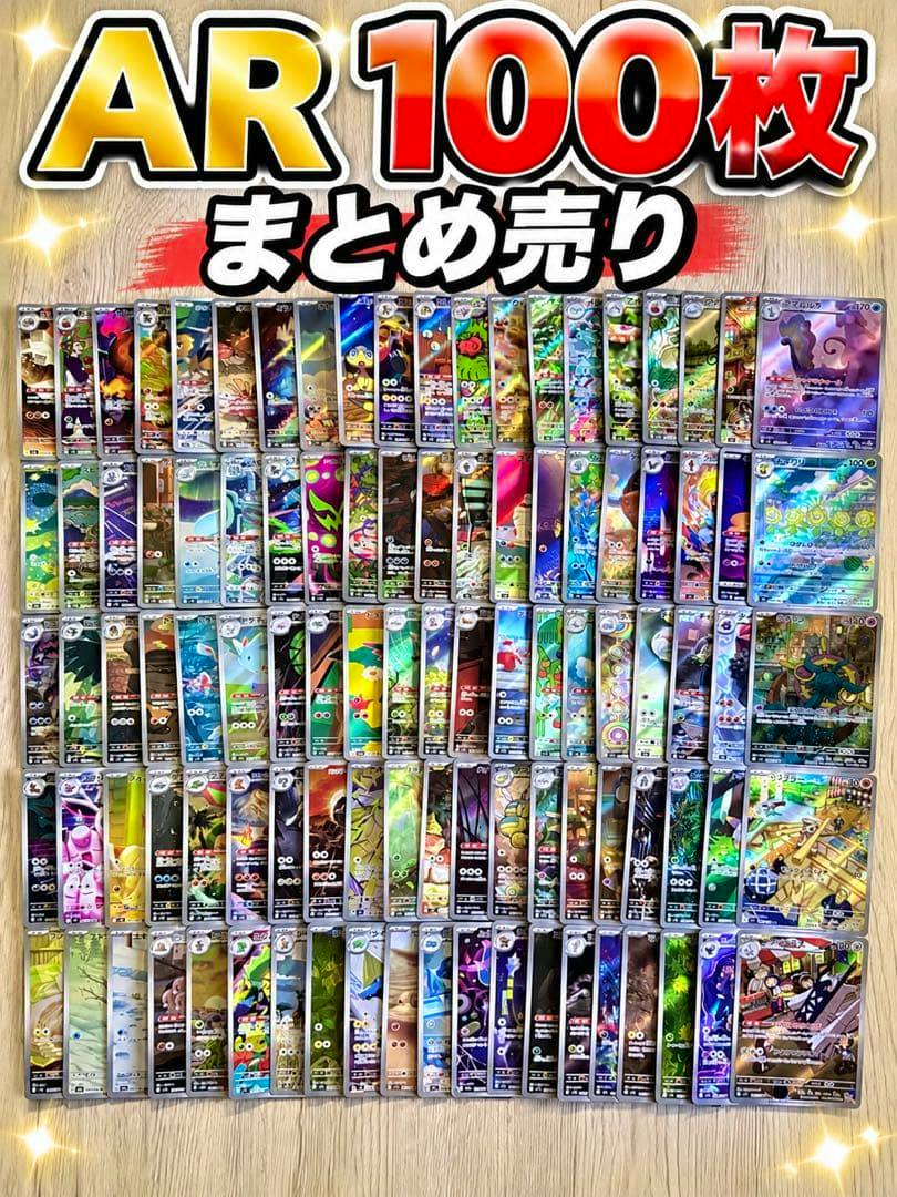 Flat lay of many Pokémon AR trading cards arranged in rows on a wooden floor with large promotional 'AR 100枚 まとめ売り' text at the top.