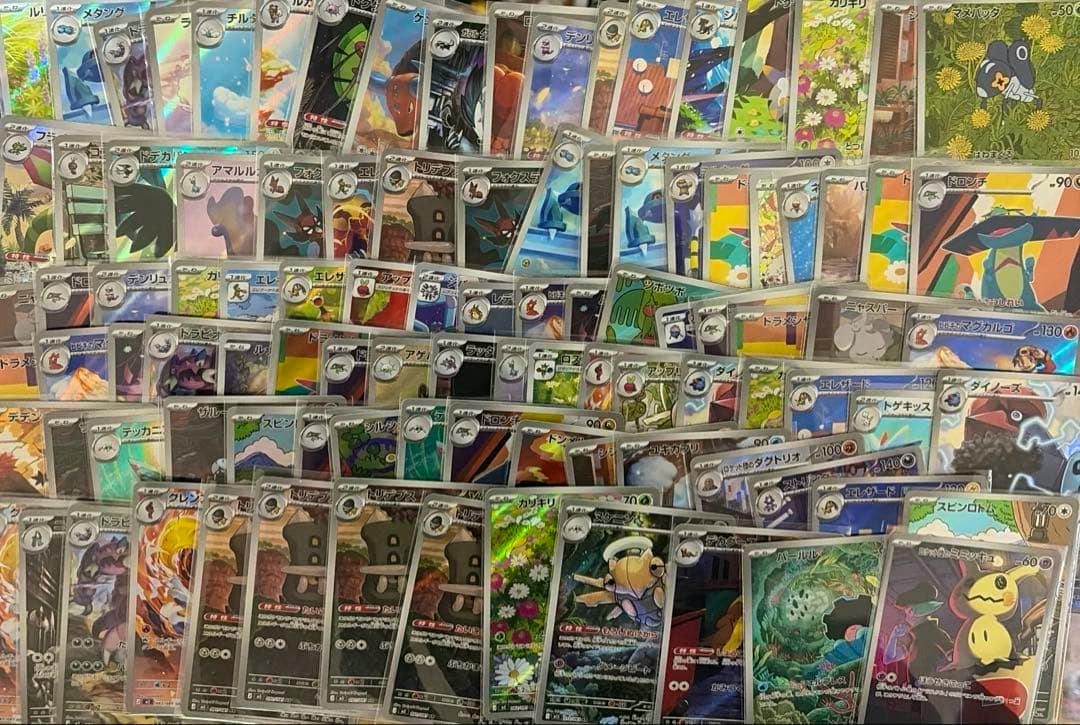 A spread of many holographic Pokémon trading cards arranged overlapping, showing various card artworks and foils.