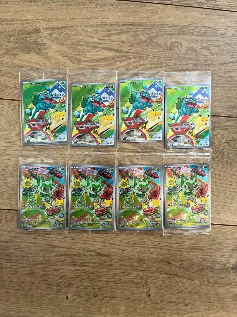 Eight Pokémon promo trading cards (Bulbasaur / フシギダネ and Sprigatito / ニャオハ) in individual sleeves arranged in two rows on a wooden surface.
