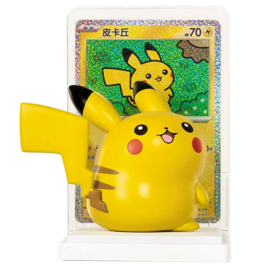Photo of a Pikachu plastic figure displayed on a white base with a Pokémon card illustration in a clear holder behind it.