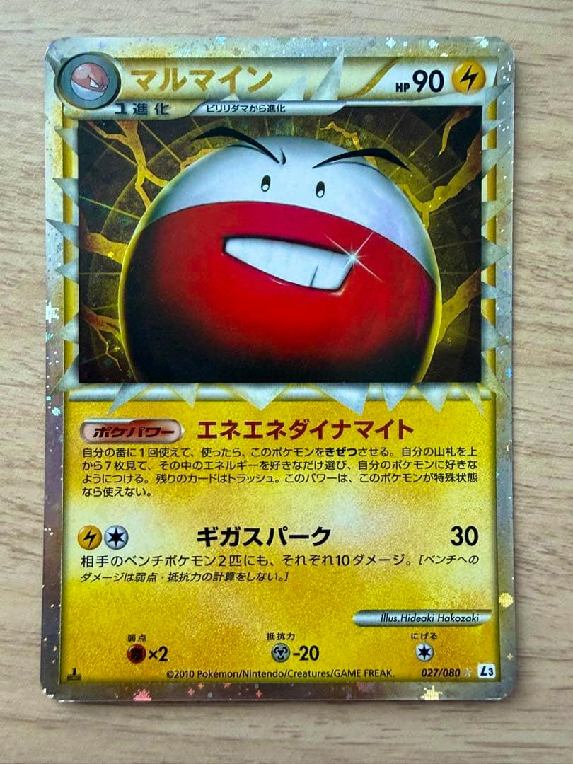 Front photo of the Pokémon trading card マルマイン (027/080 L3) showing the full card face on a wooden surface.