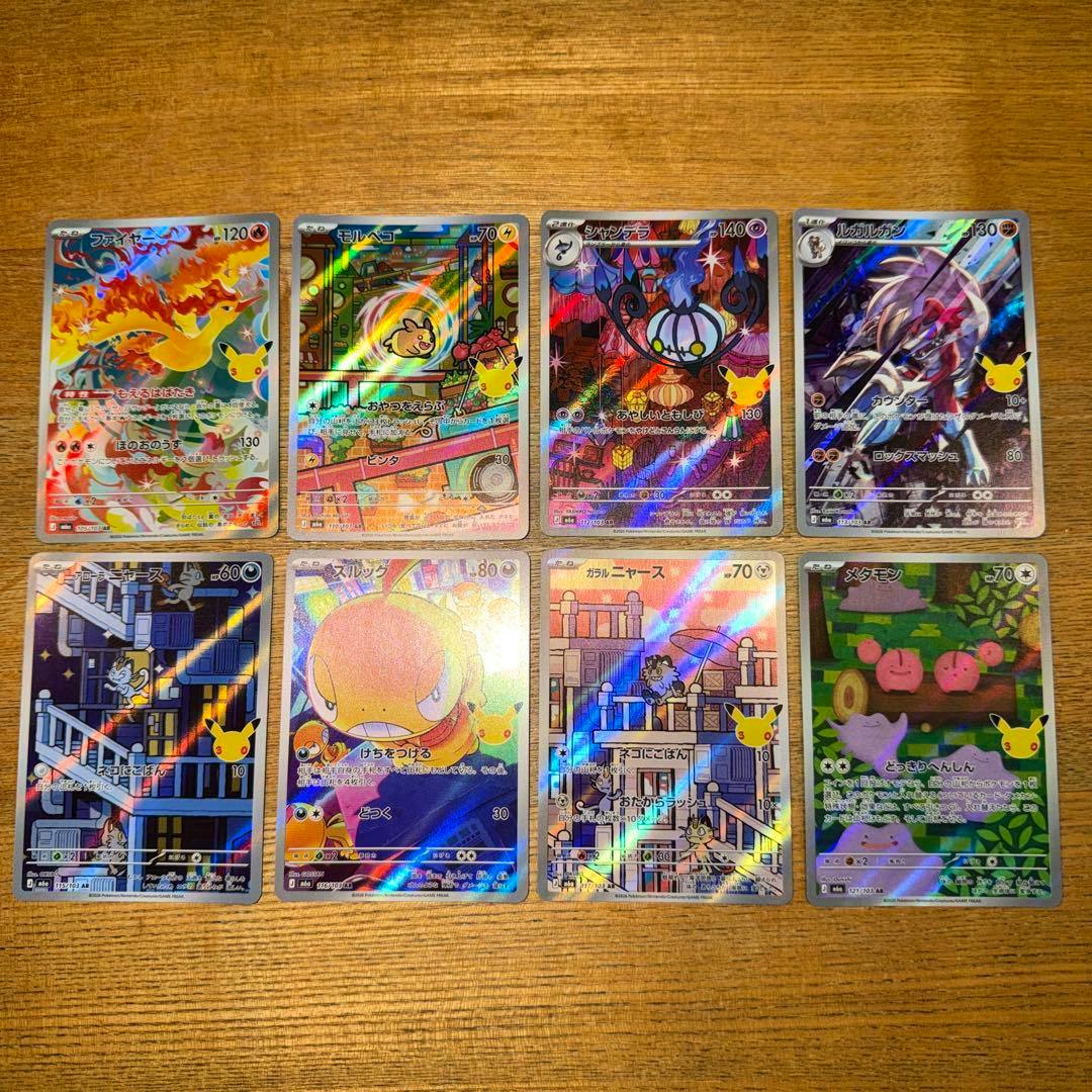 Eight Pokémon trading cards from the 30th anniversary AR set laid out in two rows showing holographic fronts on a wooden surface.