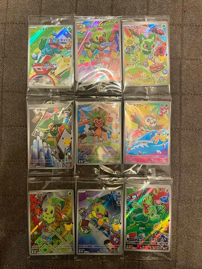 Nine Pokémon trading cards in individual protective sleeves arranged in a 3x3 grid on a dark textured surface.