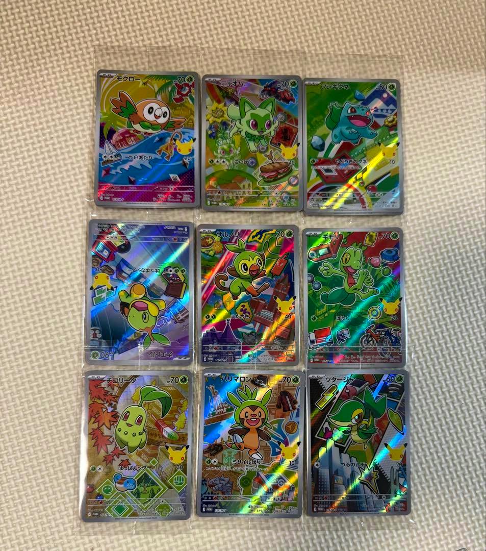 Nine Pokémon 30th anniversary promotional AR trading cards in sleeves arranged in three rows on a beige textured surface.