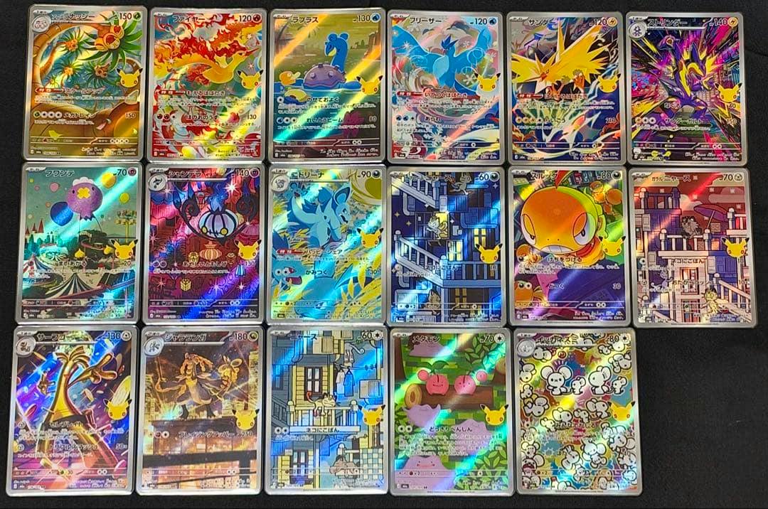 Photo of 17 holographic Pokémon trading cards from the 30th Celebration set arranged in a grid on a dark surface.