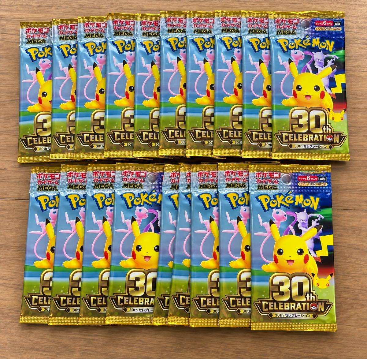 Twenty Pokémon 30th Celebration trading card booster packs arranged on a wooden surface, showing the front packaging.