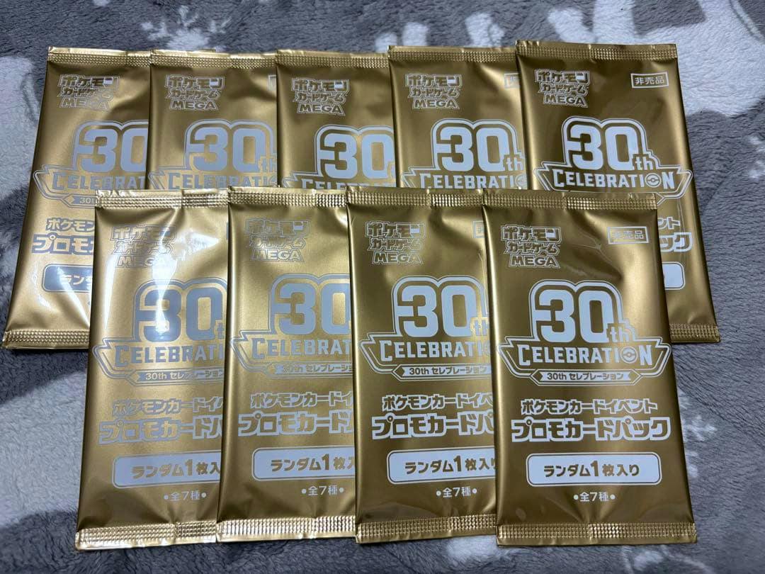 Nine sealed gold "30th Celebration" Pokémon promotional card packs arranged on a surface.