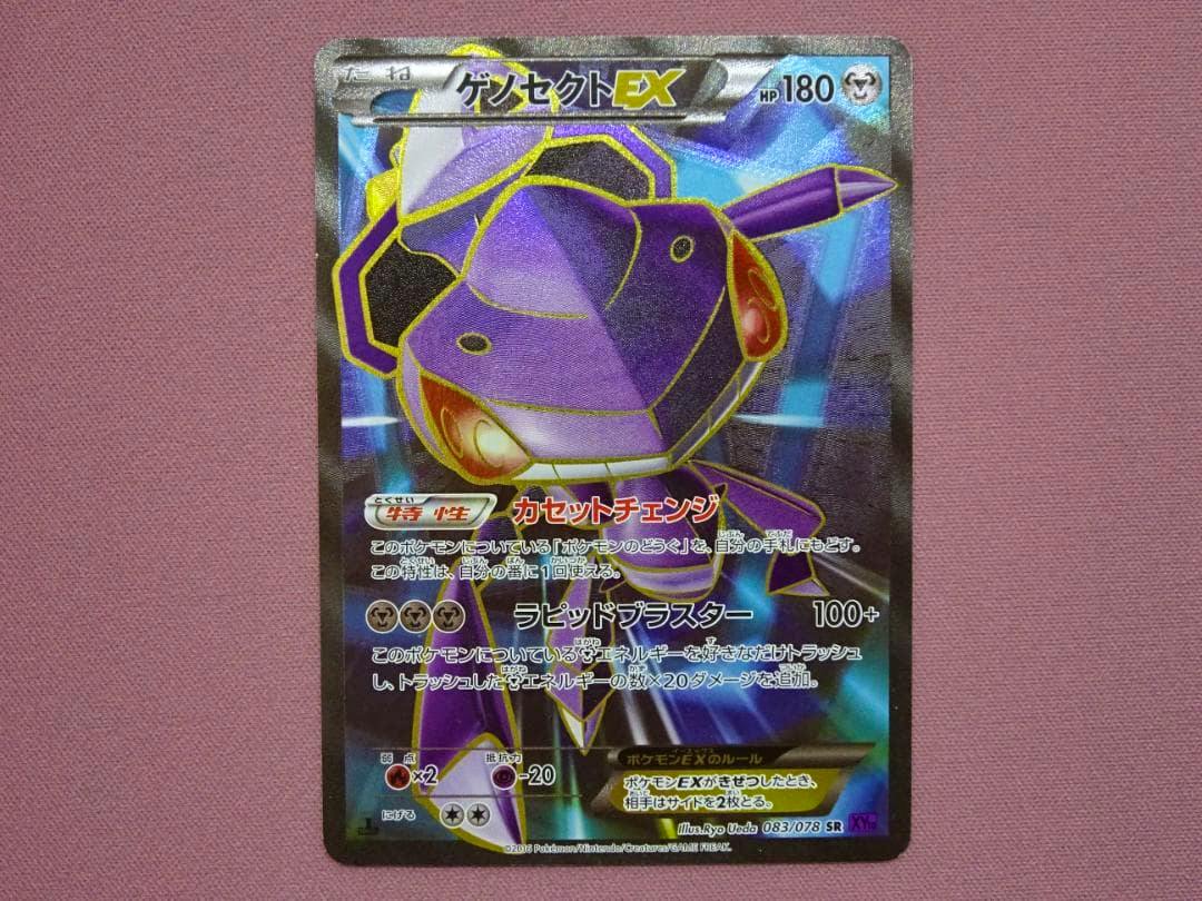 Front of a Japanese Genosect EX (ゲノセクトEX) Pokémon trading card placed on a pink fabric background.