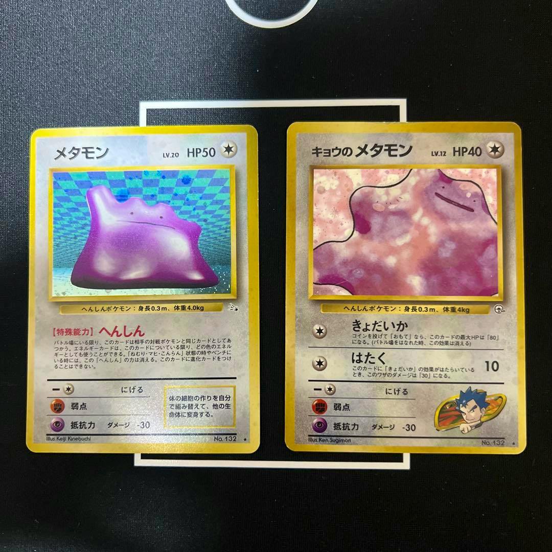 Two Japanese Pokémon trading cards (old-back) showing メタモン and キョウのメタモン placed side-by-side on a black surface.
