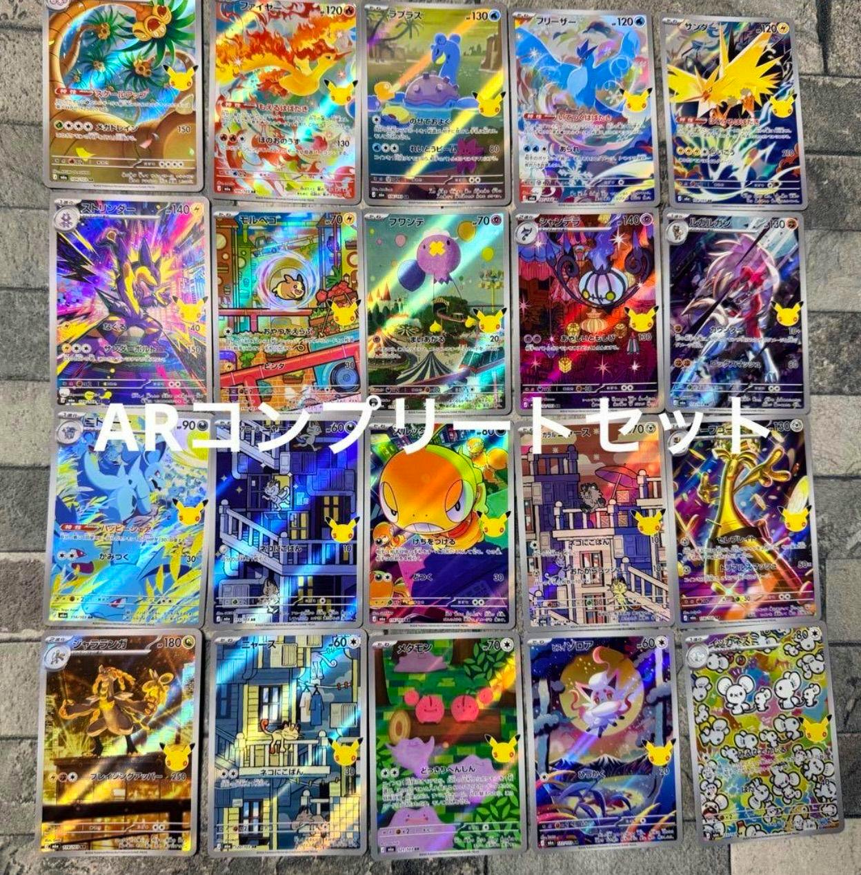 Twenty Pokémon 30th celebration AR trading cards laid out in a grid on a surface.