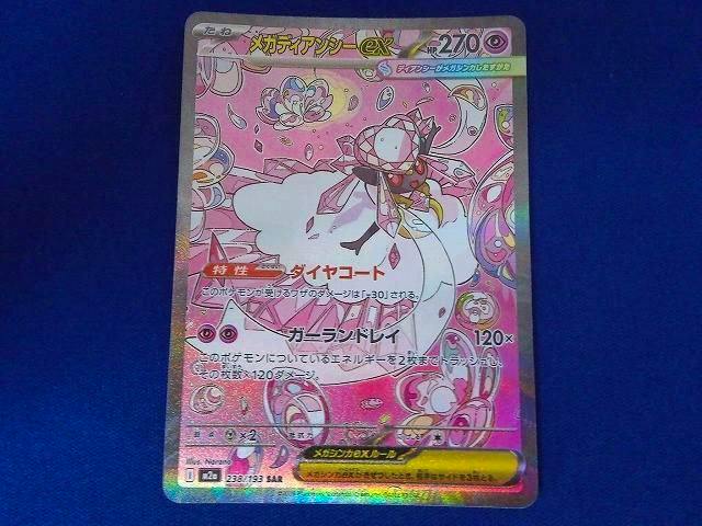 Front photograph of the trading card メガディアンシーex (M2a-238 SAR) placed on a blue background.