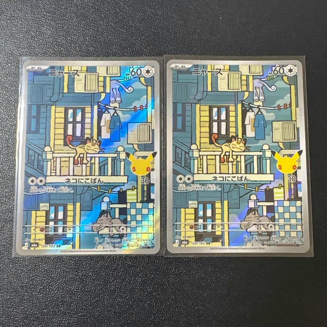 Two sleeved Pokémon trading cards showing the Meowth front artworks (120/103) with holographic finish on a dark background.