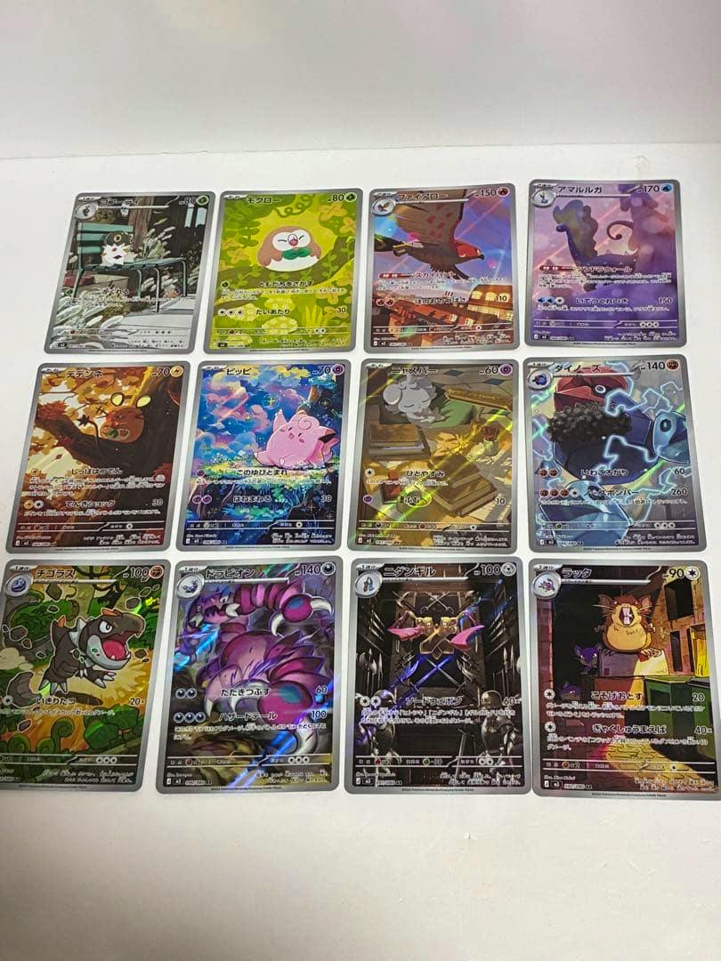 Twelve Pokémon trading cards laid out in a 3x4 grid on a white background showing colorful full-art AR cards.