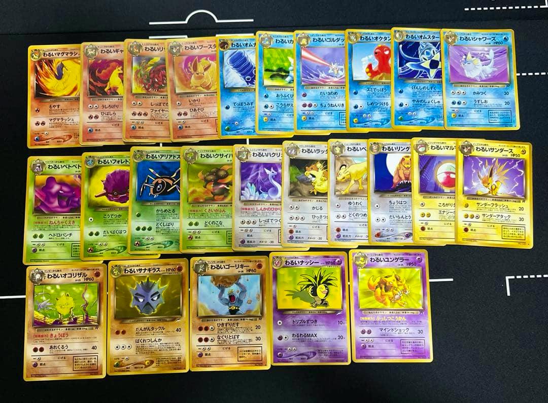 Top-down photo of the 25 Dark-series Pokémon trading cards arranged in rows on a black background.
