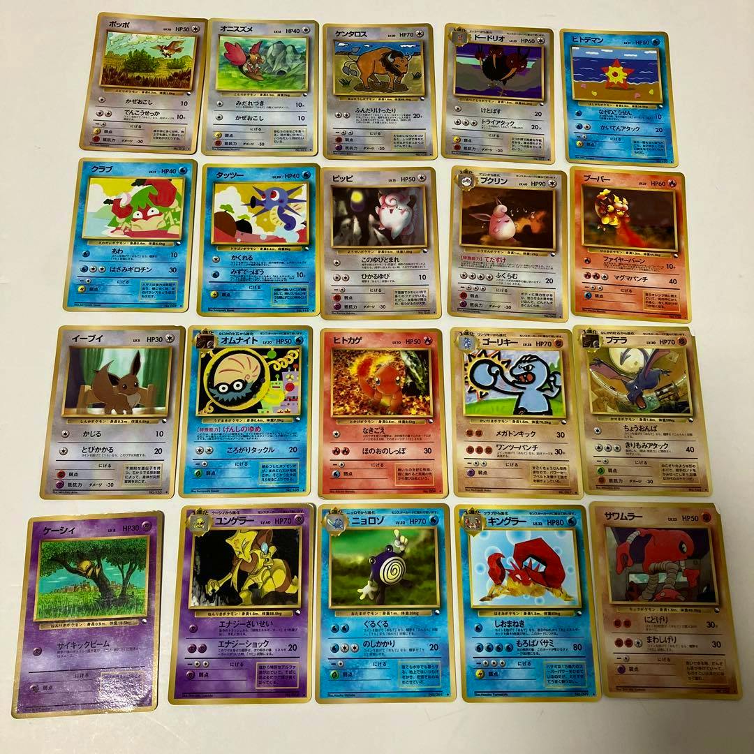 Flat lay of many Japanese Pokémon trading cards arranged in a grid on a white surface.