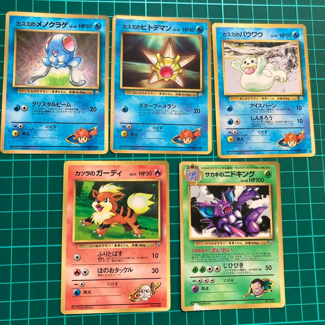 Photo of multiple Japanese Pokémon trading cards from the old-back Gym expansion, including Misty trainer cards, laid out on a green grid cutting mat.