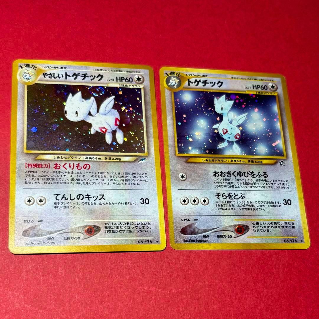 Two Japanese Togetic Pokémon trading cards shown face-up on a red background.