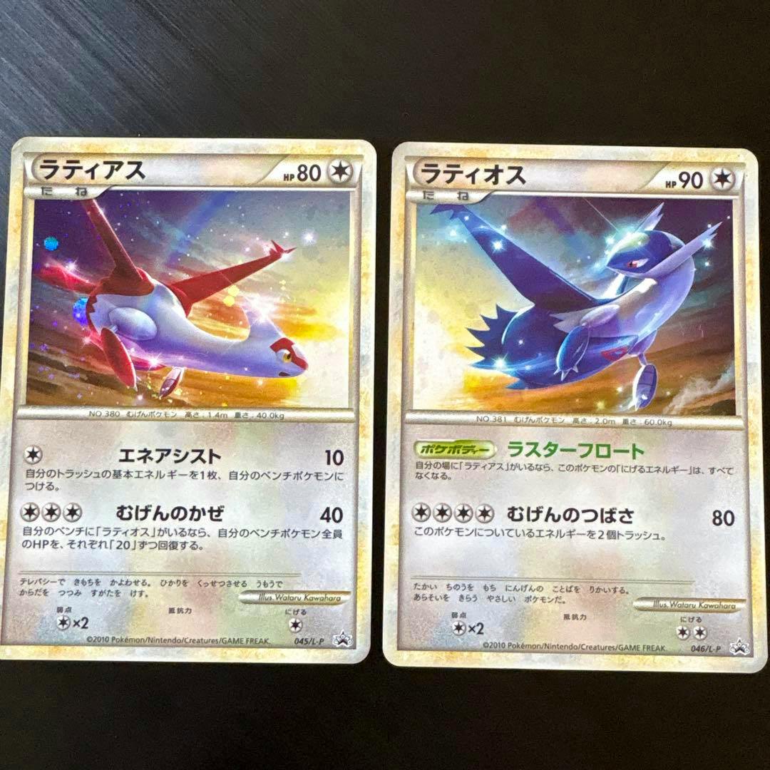 Two Pokémon trading cards showing Latias (left) and Latios (right) are photographed side by side on a dark surface.