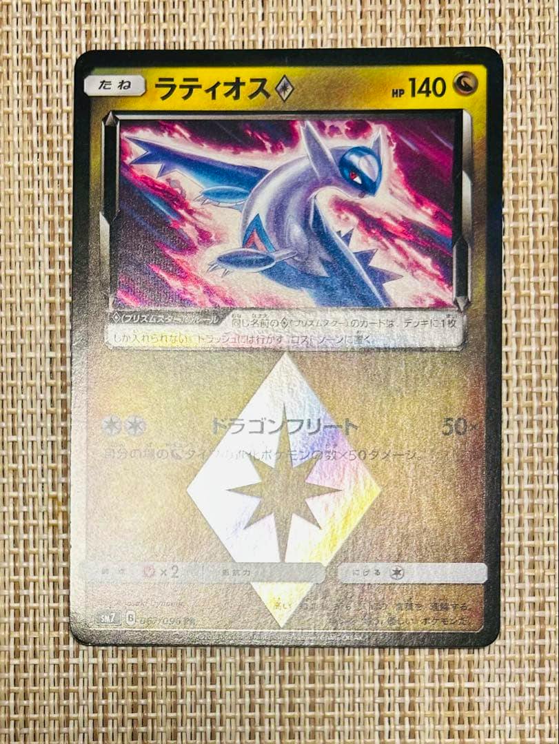 Front view photograph of the Latios PR Pokémon trading card (Sun & Moon) showing the full holographic card on a woven background.